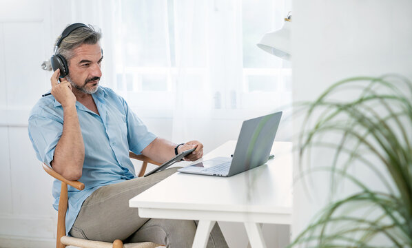 Portrait Of Happy Caucasian Business Senior Man Casual Cloths Shirt Work In Home Office Desk Using Head Phone Computer. Small Business Employee Freelance Online Sme Marketing E-commerce Telemarket