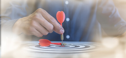 Businessman holding a darts aiming at the target center,business growth success concept.