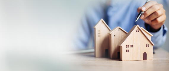 Business hand holding home with Buy or Rent, copy space. Property investment and house mortgage...