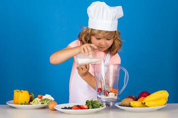 Child chef dressed cook baker apron and chef hat cooking milk shake smoothie isolated on studio background. Healthy nutrition kids food.