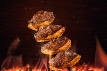 Picaña a la estaca sobre la brasa y un fondo de textura