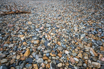 Multi-colored round rocks on Little Hunters Beach in Acadia National Park, Maine. Tide coming in as waves crash. 