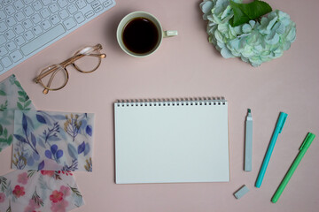Colorful pen and envelops with a white notebook on pink background. 