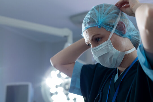 Caucasian female surgeon in an operating theatre, wearing face mask