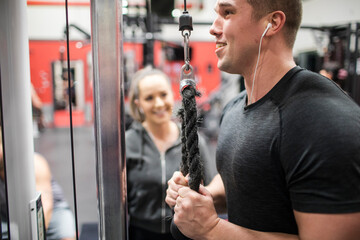 Attractive personal trainer works with client at the gym.