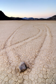 Rocks create trails of their movement across the famous Racetrack in Death Valley National Park at sunset, CA.