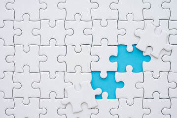 Fototapeta premium The last two piece of jigsaw puzzle to complete task on blue background. Business strategy teamwork, problem solving concept. Teamwork is collaborative effort of team to achieve goal