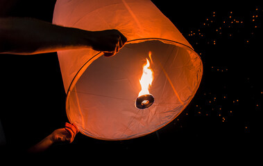Person holding paper lantern during Yi Peng festival, Chiang Mai, Thailand