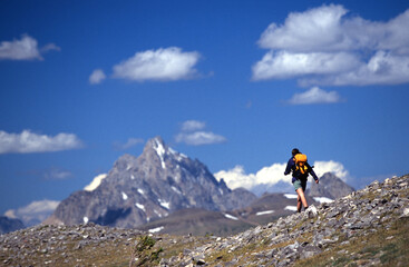 Woman backpacking along a rocky ridge.