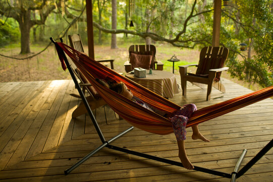 Young girl relaxing in hammock on porch of home on Sapelo Island, Georgia.