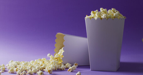 Image of two white popcorn tubs on purple background