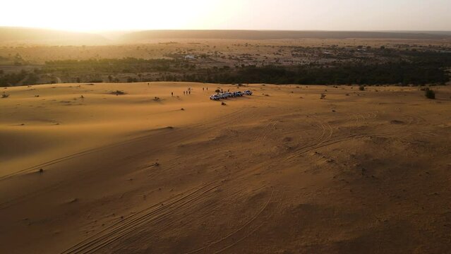 Cars on Sand Dunes with Beautiful Sahara Desert Sunset in Background, Mauritania, Africa - Aerial Orbit