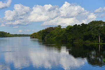 Clouds reflections on a tranquil stretch of the Guaporé - Itenez river near the remote village of...