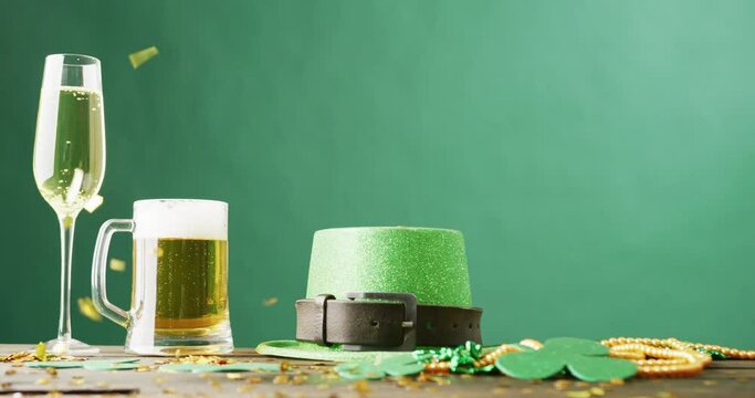 Video of st patrick's glass of champagne, beer, hat with copy space on green background