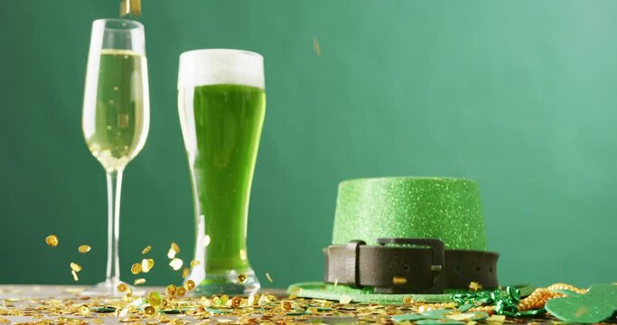 Video of st patrick's glass of champagne, beer, hat with copy space on green background