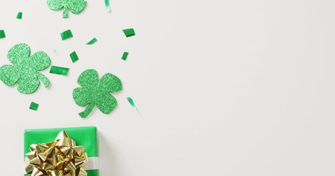 Video of st patrick's shamrock leaves and present with copy space on white background