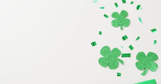 Video of st patrick's shamrock leaves and present with copy space on white background