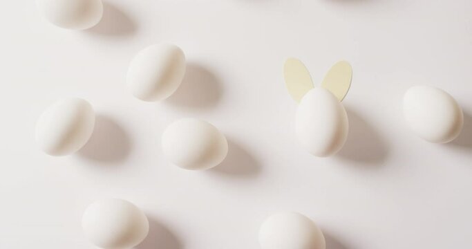 Multiple white easter eggs with rabbit ears on white background