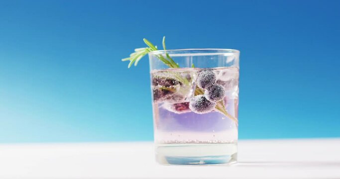 Close up of transparent drink with bluberries on blue background
