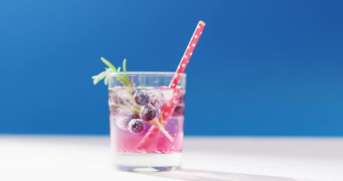 Close up of transparent drink with bluberries on blue background
