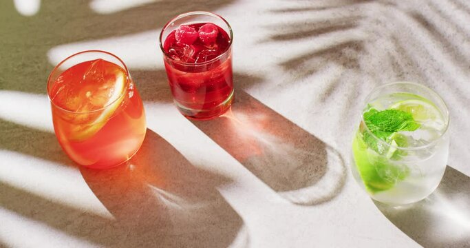 Close up of drinks with orange, raspberry and lemon over shadow