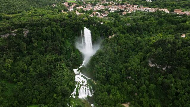 Man-made Waterfall Marmore Falls With Mist, Surrounded By Lush Green Forest In Umbria, Italy. aerial