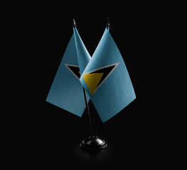 Small national flags of the Saint Lucia on a black background