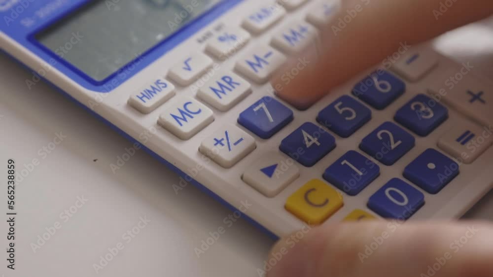 Aufkleber hand uses calculator in calculating numbers. closeup