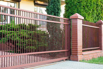 Beautiful brick fence with brown iron railing outdoors