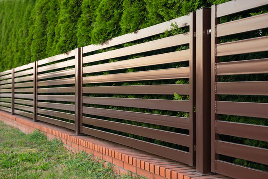 Beautiful fence with brick and brown iron railing