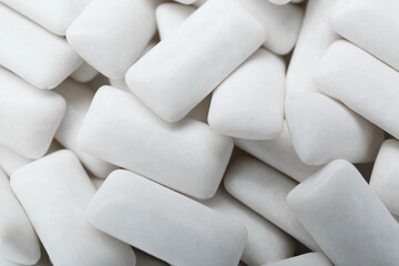 Tasty white chewing gums as background, top view