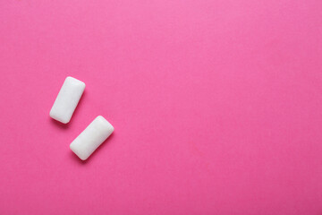 Tasty white chewing gums on pink background, flat lay. Space for text