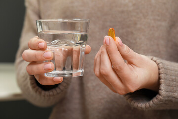 Fototapeta Woman holding glass of water and pill, closeup view obraz