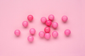 Many bright chewy gumballs on pink background, flat lay