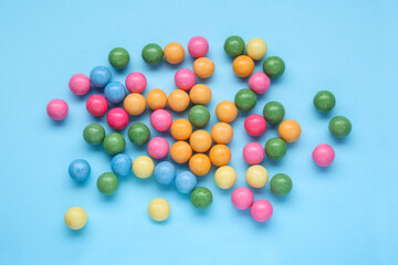 Many bright gumballs on light blue background, flat lay
