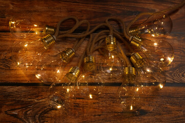 String lights with lamp bulbs on wooden table, top view