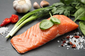 Fresh salmon and ingredients for marinade on black table, closeup