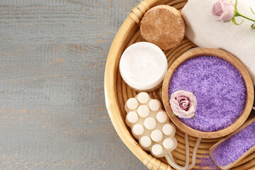 Sea salt and different spa products on light grey wooden table, top view. Space for text