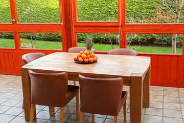 Wooden table with fruits and stylish chairs on terrace