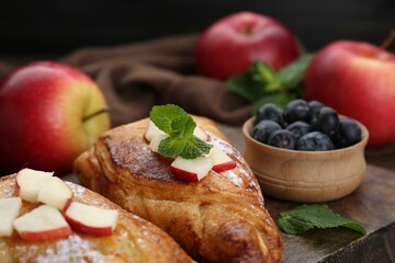 Fresh tasty puff pastry with blueberries, apples and mint served on table, closeup
