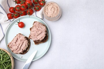 Delicious liverwurst sandwiches, tomatoes and arugula on white table, flat lay. Space for text