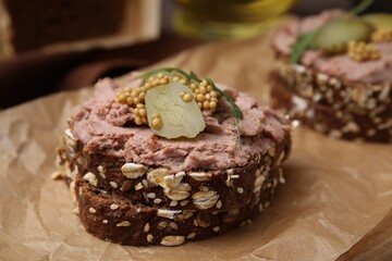 Delicious liverwurst sandwiches with pickled cucumber and mustard on table, closeup