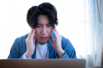 頭を抱えて考える男性　困った、驚き、炎上のイメージ