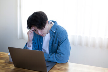 頭を抱えて考える男性　エンジニアなどのイメージ