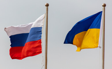 Flags of Russia and Ukraine against the sky.