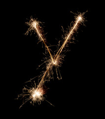 Sparkling burning creative letter Y isolated on black background. Beautiful glowing golden overlay object for design holiday greeting card. Creative lettering Y written with burning sparklers