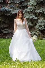 Obraz na płótnie Canvas Girl in a wedding dress in nature.