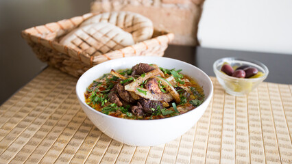 Bowl with hummus and chicken served with pita bread.