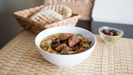 Bowl with hummus and lamb served with pita bread.