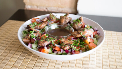 Tomato, onion and cucumber salad with chicken and sauce.
